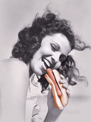 kvinna äter hotdog